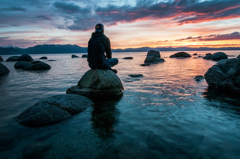 Person practising calm deep breathing in soft natural light