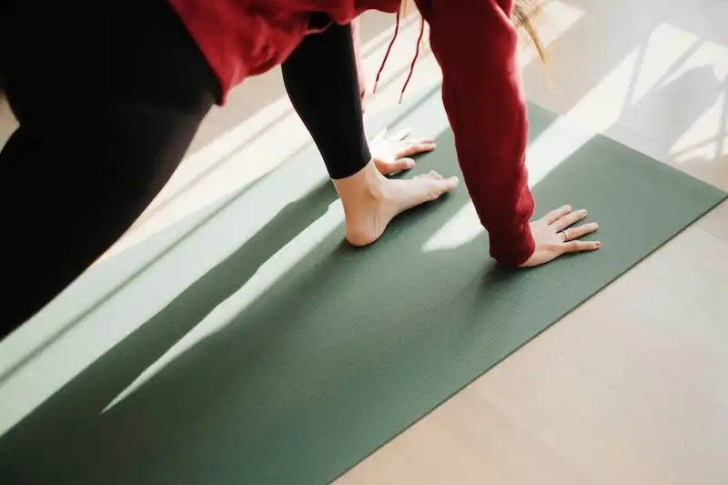 Person stretching on a mat in a calm gym studio