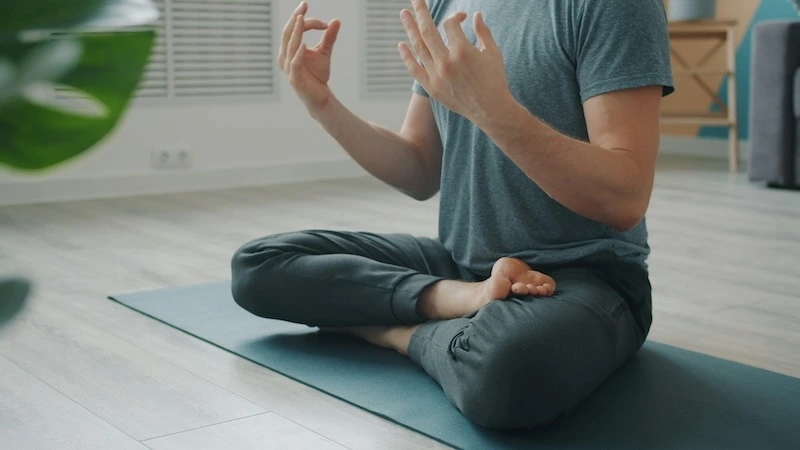 Person meditating quietly in a calm, softly lit space