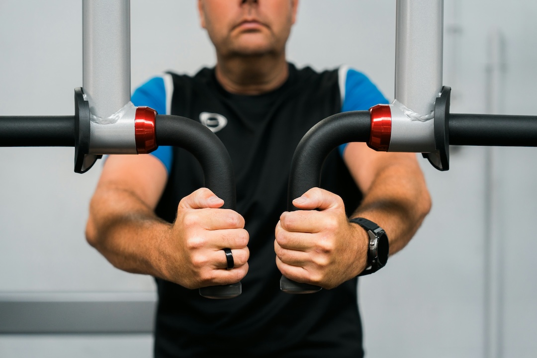 A man building muscle using gym machines at Atlantis Gym in Tiptree, Essex